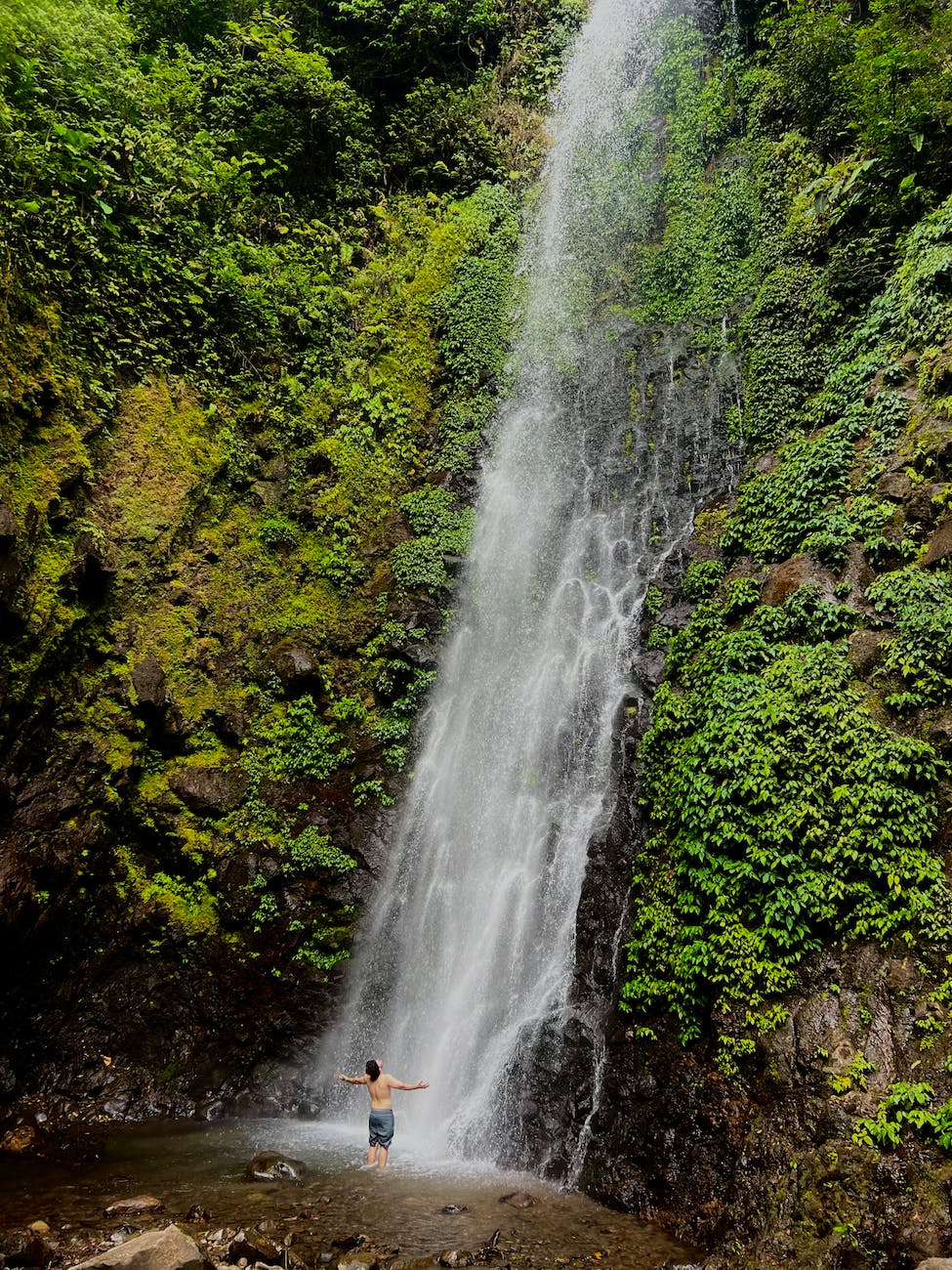 a man standing in front of a waterfall